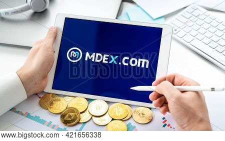 Russia Moscow 06.05.2021.businessman With Tablet.logo Of Cryptocurrency Stock Exchange Mdex.com.trad