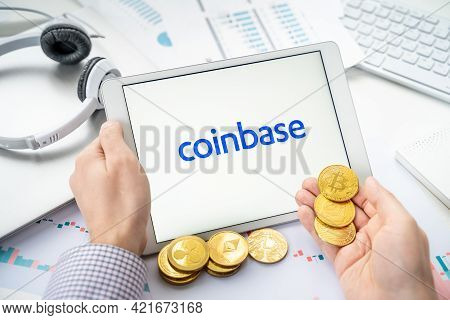 Russia Moscow 06.05.2021.businessman With Tablet.logo Of Cryptocurrency Stock Exchange Coinbase.trad
