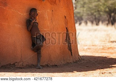 OPUWO, OTJIWARONGO REGION NAMIBIA - MAY 4, 2021: Young unidentified Himba boy with the typical necklace in Himba living museum during a appearance in front of tourists
