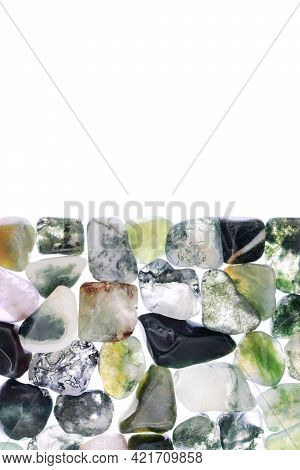 Moss Agate Heap Jewel Stones Texture On Half White Light Isolated Background. Place For Text.