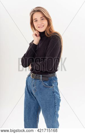 Portrait Of Young Attractive Caucasian Woman With Long Hair In Black Turtleneck, Blue Jeans Isolated