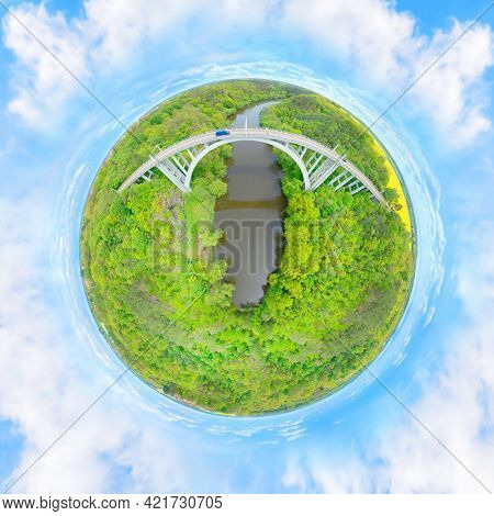 Bridge over river in deep forest. Tiny planet as a symbol of connectivity. 