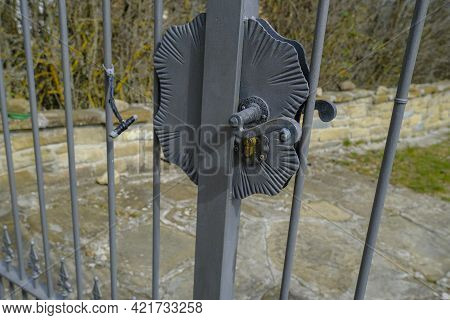 Vintage Metallic Gray-colored Padlock On The Fence Close-up Across The Backyard. Keylock