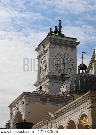 Clock Tower And Two Bronze Statues Above In The Main Square Of The City Of Udine In Northern Italy