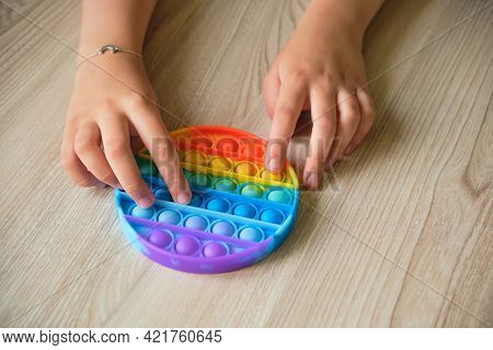 Anonymous Child Playing With The Colorful Pop It Toy.