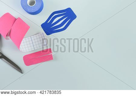 Rolls Kinesiology Tape For Application On Blue Background.