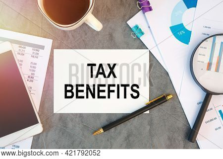 Tax Benefits Is Written In A Document On The Office Desk With Office Accessories, Coffee, Diagram An