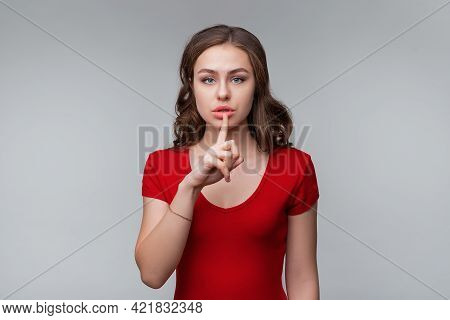 Keep It Quiet. Serious Young Brunette Woman Hiding Secret, Making Hush Silence Shh Gesture, Holding 