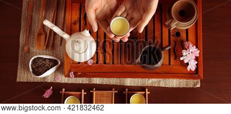 Woman With Cup Of Freshly Brewed Tea During Traditional Ceremony At Wooden Table, Top View. Banner D