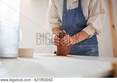 Close Up Of Potter Working With Fireclay
