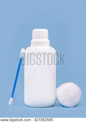 Hydrogen Peroxide, In White Plastic Bottle, With Cotton Swab And Isolated Blue Background, Medicine 