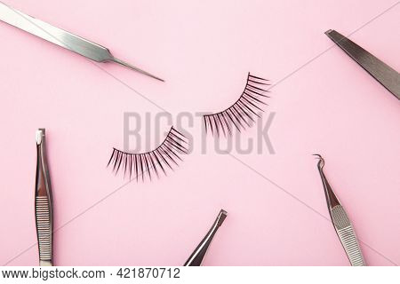 Set Of False Eyelashes Extencions On Pink Background With Tweezers. Minimalism. Top View