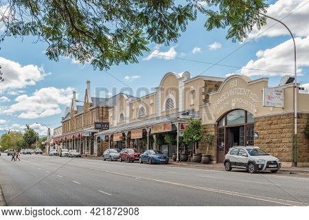 Oudtshoorn, South Africa - April 5, 2021: A Street Scene, With Businesses, People And Vehicles, In O