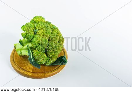 Large Raw Fresh Head Of Broccoli Cabbage On A Wooden Board, White Background, Healthy Vegetarian Foo