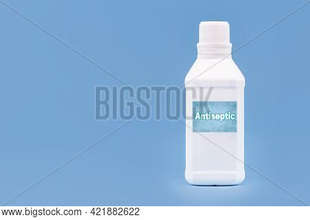 Plastic Container, Bottle Written In English: Antiseptic, Solid Blue Background With Copy Space