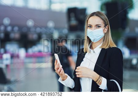 Adult female passenger using smartphone at the airport