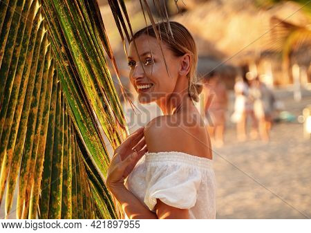 Cheerful Young Woman Enjoying A Day On The Sea Shore At Sunset.