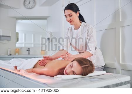 Focused Female Masseur Doing A Deep Tissue Massage Therapy In Spa Senter