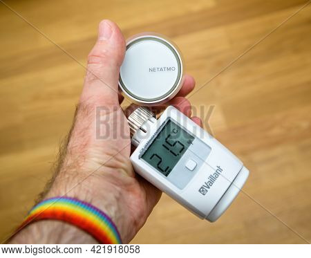 Paris, France - Apr 21, 2021: Pov Male Hand Holding Netatmo By Stark Intelligent Radiator Thermostat
