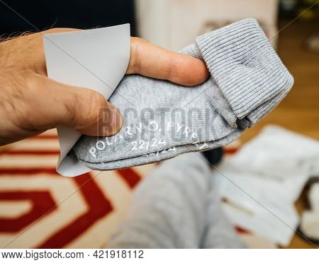 Lyon, France - May 2, 2021: Pov Male Hand Father Holding Infant Baby Socks Manufactured By The Swedi