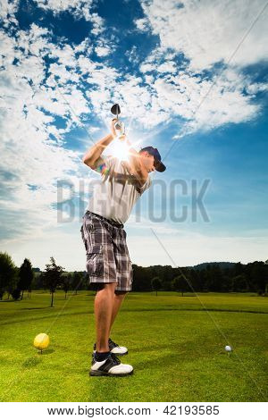 Young golf player on course doing golf swing, he presumably does exercise