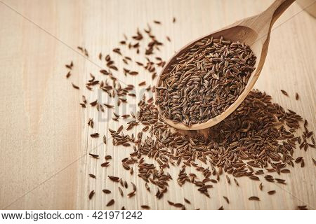 Close Up Caraway Seeds. Dried Caraway Seeds In Wooden Spoon On The Table. Pile Of Cumin Seeds. Seaso