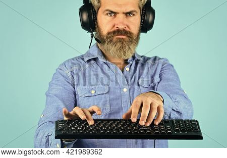 Software Engineer Working. Digital Music Creation. Bearded Man Listen Headphones And Keyboard. Commu