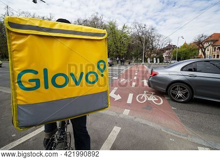 Bucharest, Romania - April 15, 2021: Glovo Food Delivery Couriers Deliver Food In Bucharest, Romania