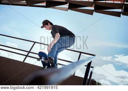 Skateboarder Jumping High On Mini Ramp At Skate Park Outdoor.