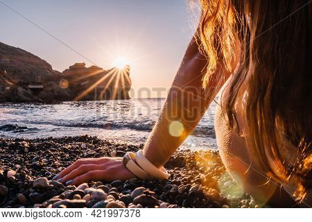 Young Woman With Long Hair In White Swimsuit And Boho Style Braclets Practicing Outdoors On Yoga Mat