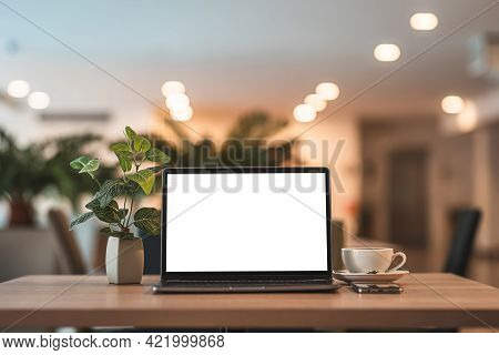 Mockup Of Laptop Computer With Empty Screen With Coffee Cup And Smartphone On Table Of The Coffee Sh