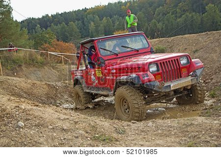 Red Car Is Passing Through  A Puddle Of Mud