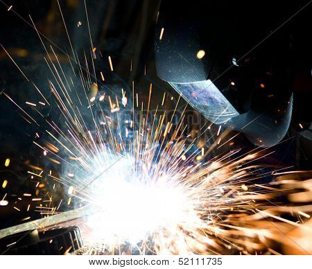 Welders in action with bright sparks. Construction and manufacturing theme.