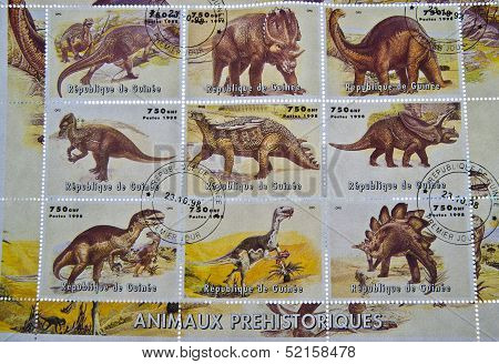 A stamp printed in the Republic of Guinea whit different images of dinosaurs