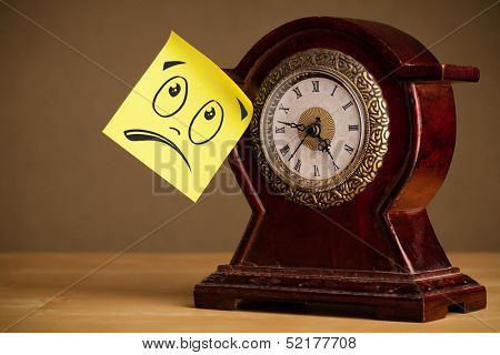 Drawn smiley face on a post-it note sticked on alarm clock