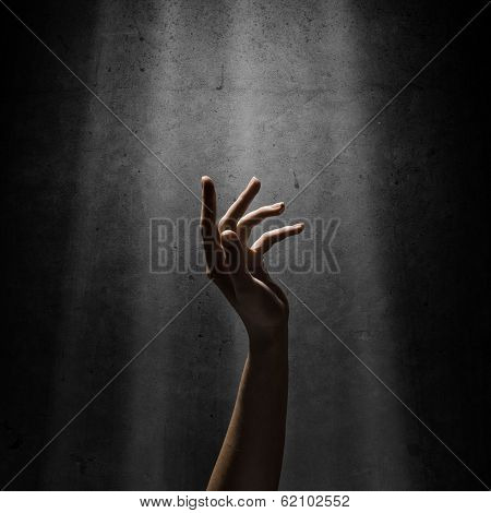 woman's hand reaches for the light rays