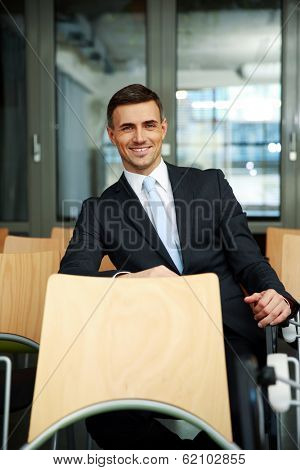 Smiling businessman sitting at conference hall