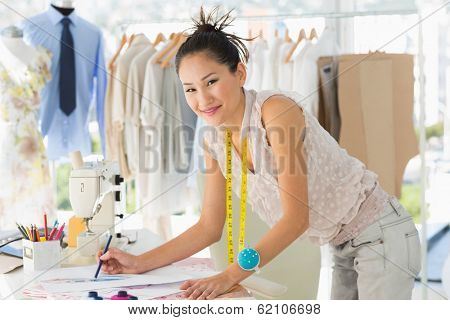 Side view of a young female fashion designer working on her designs in the studio