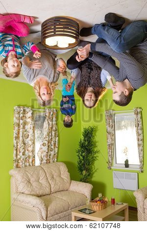 Family of five sits on the ceiling upside down with candles at inverted house
