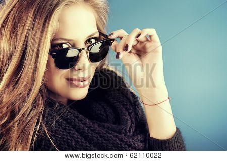 Close-up portrait of a smiling young lady with beautiful hair wearing black sunglasss.