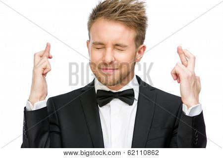 Half-length portrait of manager with fingers crossed and eyes closed, isolated on white