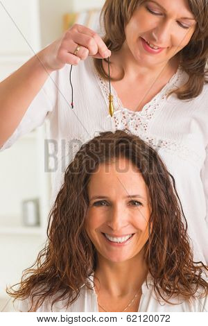 Alternative medicine therapist using pendulum to make a diagnosis