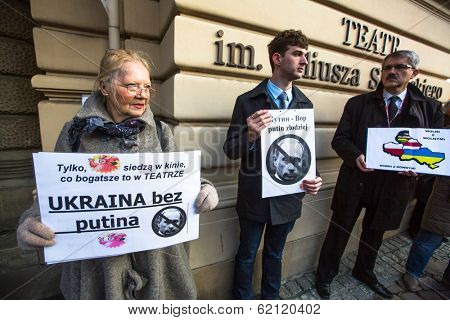 KRAKOW, POLAND - MAR 9, 2014: Unidentified participants during protest near Cracow Opera, against bringing Russian troops in the Crimea. Posters: Ukraine without Putin, and Putin - Thief.