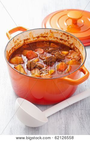 beef stew with potato and carrot in red casserole