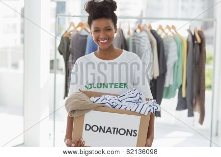 Portrait of a smiling young woman with clothes donation