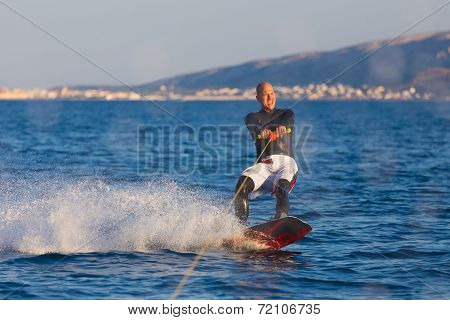 Wakeboarder in sunset.