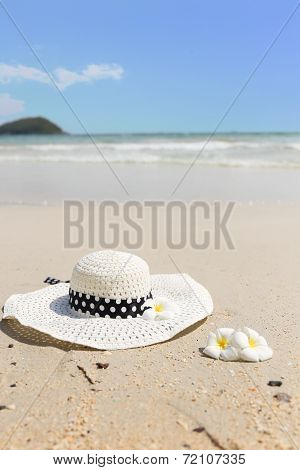 Straw Hat And Plumeria On The Beach