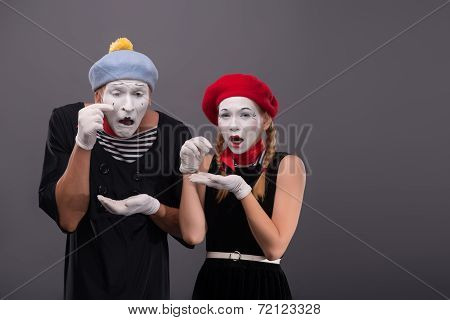 Portrait of sad mime couple crying isolated on grey background