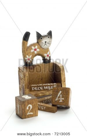 Wooden calendar with a cat who is standing on it.