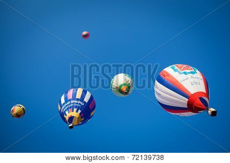 Bright colored balloons in blue sky